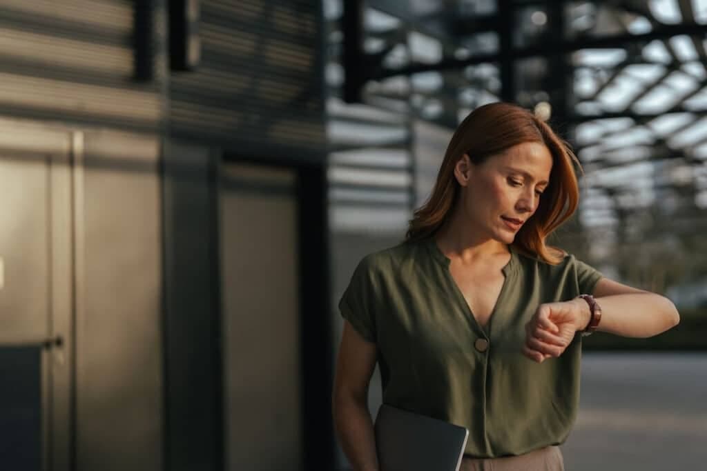 Woman with serious face checking her wristwatch.